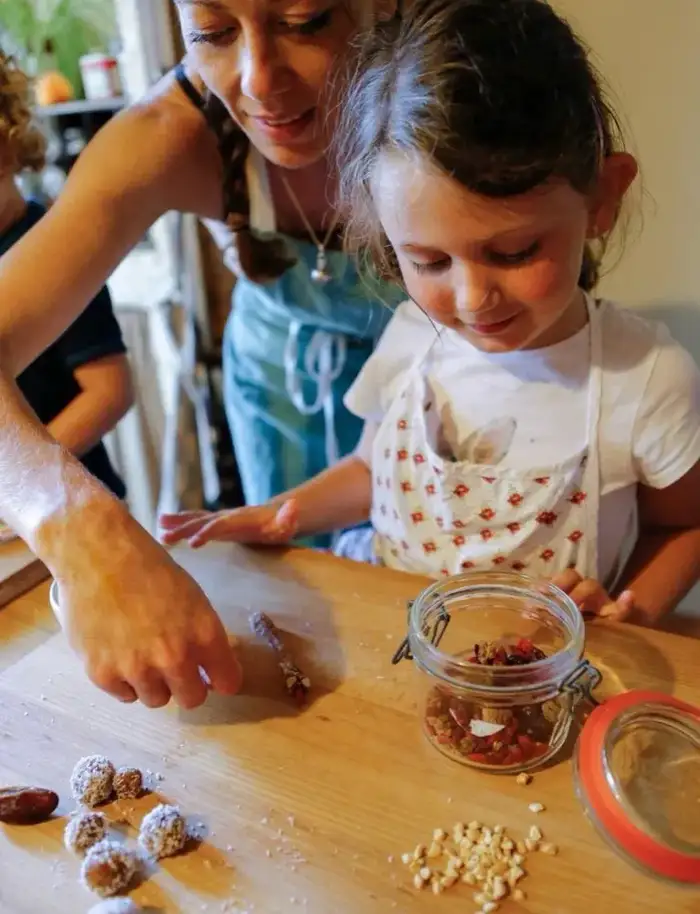 Frédérique Barral et une enfant préparant des boules d'énergie lors d'un atelier de cuisine