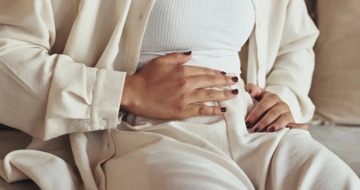 Une femme assise, les mains posées sur son ventre
